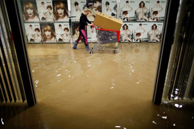 Una mujer empuja un carrito mientras evacua un salón de belleza en un centro comercial durante las inundaciones en la ciudad bosnia de Zenica central  / Dado Ruvi? / Reuters