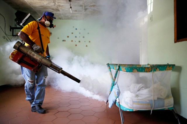 Worker carries out fumigation to help control the spread of Chikungunya and dengue fever, which are caused by viruses carried by mosquitoes, in the Petare slum district of Caracas