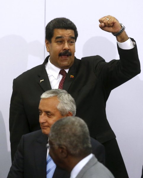 Venezuela's President Nicolas Maduro holds up his fist as Guatemala's President Otto Perez Molina stands near during the family photo of the VII Summit of the Americas in Panama City