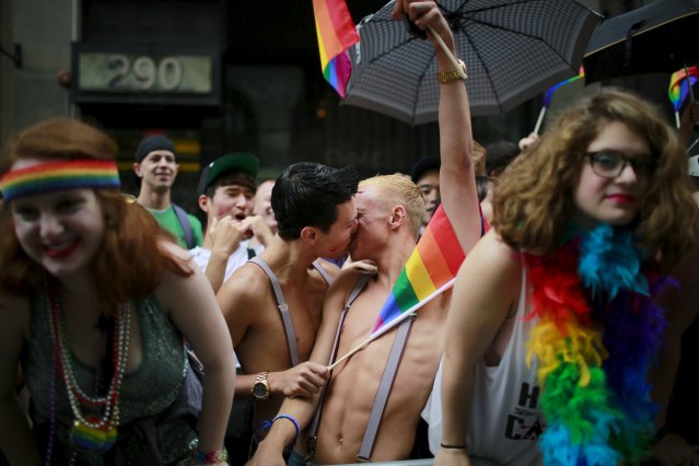 Spectators kiss while they cheer marchers during the annual Gay Pride parade in New York