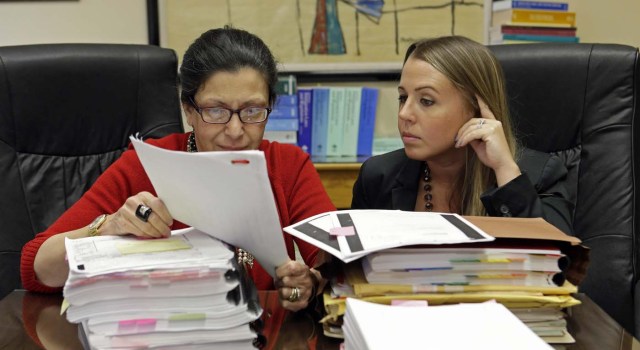 Las abogadas Grisel Ybarra (izquierda) y Mónica Barba Neumann mientras revisan documentos en su oficina en Miami.  (Foto AP/Alan Díaz)