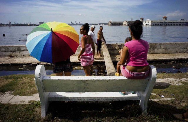 Varias personas aguardan para el inicio de una competición de nado en la bahía de La Habana durante una pequeña feria en el barrio Casablanca de la capital cubana, el jueves 16 de julio de 2015. (Foto AP/Ramón Espinosa)