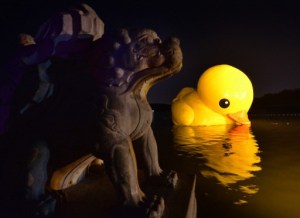 El pato inflable de 18 metros de altura se acercó a una estatua de un dragón chino (Fotos)