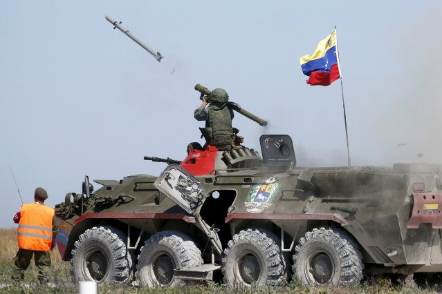 A serviceman from Venezuela fires an anti-aircraft missile with a Russian-made Igla ground-to-air launcher as he sits on top of an armoured personnel carrier (APC) during the Air defense battle masters competition as part of the International Army Games 2015 in the port town of Yeysk, Russia, August 9, 2015. REUTERS/Maxim Zmeyev