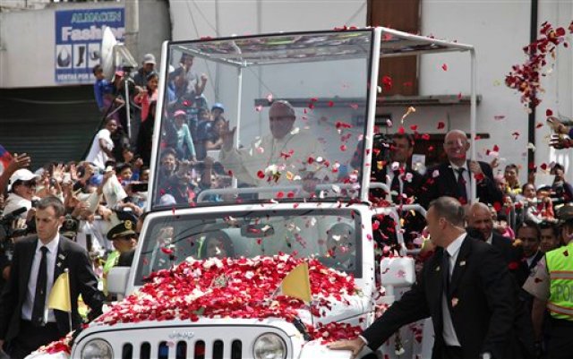 Personas arrojan pétalos mientras el papa Francisco pasa en su papamóvil en El Quinche, Ecuador, en una fotografía de archivo del 8 de julio de 2015. El Papa usará un Jeep Wrangler especialmente acondicionado durante su próxima visita a Estados Unidos, confirmó El Vaticano el viernes 21 de agosto de 2015. (Foto AP/Ana Buitron, archivo)