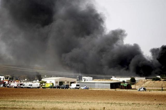 Una gran humareda cubre la zona de la explosión registrada en la empresa Pirotecnia Zaragozana, situada en Garrapinillos, un barrio de la capital aragonesa en la que cuatro personas se encuentran desaperecidas y otras cuatro están heridas muy graves.Hasta el lugar de la explosión, ocurrida en torno a las 14.15 horas, se han trasladado bomberos del Ayuntamiento y de la Diputación de Zaragoza y otros efectivos policiales.- EFE/TONI GALÁN.