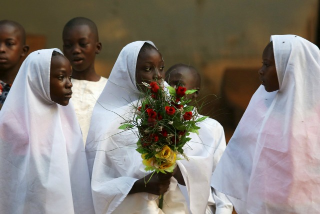 Una niña sostiene un ramo de flores como regalo para Francisco, antes de su visita a la mezquita central de la mayoría musulmana PK 5 barrio de la capital, Bangui, República Centroafricana, 30 de noviembre de 2015. REUTERS / Siegfried Modola