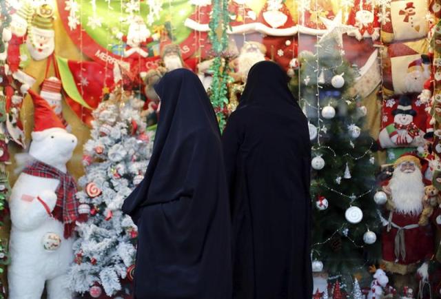 Dos mujeres observan una tienda decorada con motivos navideños, en Teherán, Irán, el 23 de diciembre del 2015. Unos 150.000 cristianos residentes en Irán, la mayoría armenios, celebran la Navidad en iglesias y en sus hogares. EFE/Abedin Taherkenareh