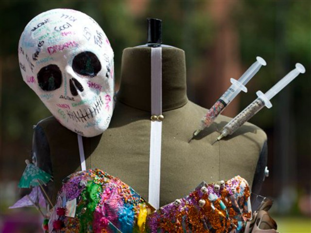 Una calavera de plástico y unas jeringas decoran un maniquí que sostiene un vestido durante una competencia estudiantil de diseño de modas inspirada en los efectos del narcotráfico en la cultura mexicana, realizada en la Universidad Iberoamericana en la Ciudad de México (Foto AP/Rebecca Blackwell)