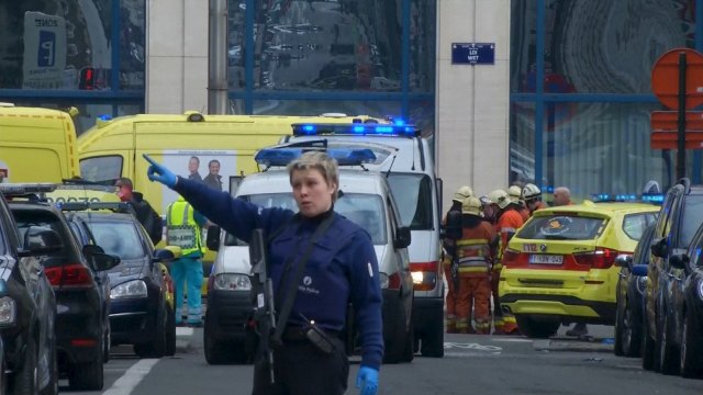 A police woman gestures in front of ambulances at the scene of a blast outside a metro station in Brussels, in this still image taken from video on March 22, 2016. REUTERS/Reuters TV