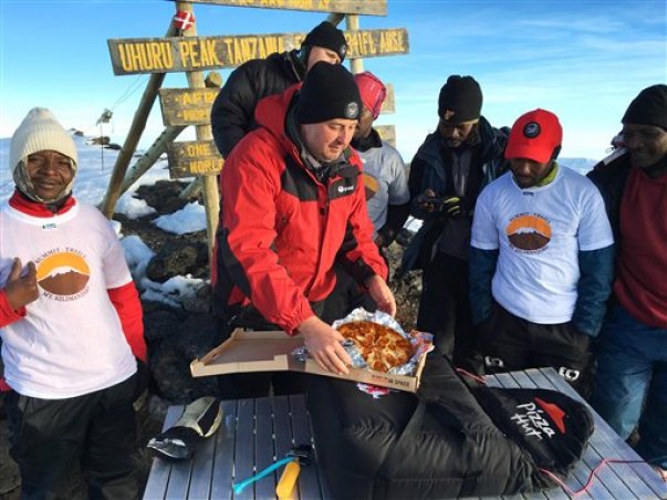 En esta fotografía del 9 de mayo de 2016 proporcionada por Pizza Hut, el gerente general de Pizza Hut África, Randall Blackford, centro, celebra haber logrado el récord mundial de la organización Guinness World Records por la entrega más elevada de una pizza en el monte Kilimanjaro en Tanzania. (Consea Dissa/Pizza Hut vía AP) CRÉDITO OBLIGATORIO