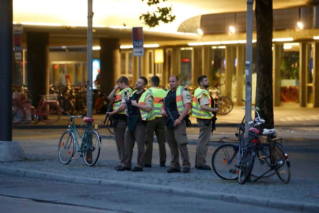 Police officers stand guard outside the main train station following a shooting rampage at the Olympia shopping mall in Munich, Germany July 22, 2016. REUTERS/Michael Dalder