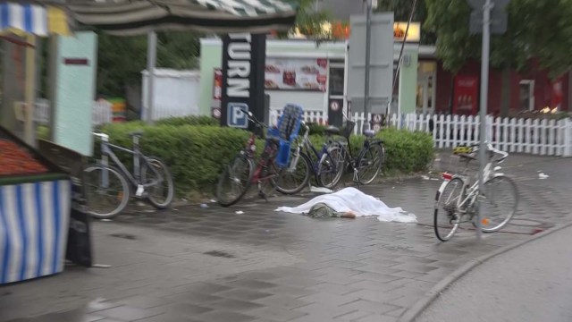 ATTENTION EDITORS - VISUAL COVERAGE OF SCENES OF INJURY OR DEATH A screen grab taken from video footage shows a covered body lying in a street following a shooting rampage at the Olympia shopping mall in Munich, Germany July 22, 2016. REUTERS/Non-stop News/Handout via Reuters TV GERMANY OUT TPX IMAGES OF THE DAY NO ARCHIVES. FOR EDITORIAL USE ONLY. NOT FOR SALE FOR MARKETING OR ADVERTISING CAMPAIGNS. THIS IMAGE HAS BEEN SUPPLIED BY A THIRD PARTY. IT IS DISTRIBUTED, EXACTLY AS RECEIVED BY REUTERS, AS A SERVICE TO CLIENTS. GERMANY OUT. NO COMMERCIAL OR EDITORIAL SALES IN GERMANY.