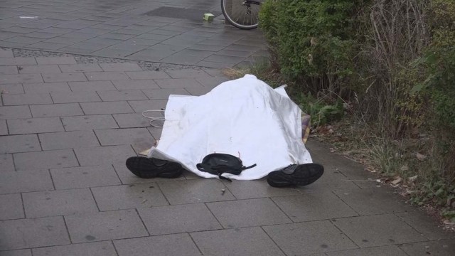 ATTENTION EDITORS - VISUAL COVERAGE OF SCENES OF INJURY OR DEATH A screen grab taken from video footage shows a covered body lying in a street following a shooting rampage at the Olympia shopping mall in Munich, Germany July 22, 2016. REUTERS/Non-stop News/Handout via Reuters TV GERMANY OUT NO ARCHIVES. FOR EDITORIAL USE ONLY. NOT FOR SALE FOR MARKETING OR ADVERTISING CAMPAIGNS. THIS IMAGE HAS BEEN SUPPLIED BY A THIRD PARTY. IT IS DISTRIBUTED, EXACTLY AS RECEIVED BY REUTERS, AS A SERVICE TO CLIENTS. GERMANY OUT. NO COMMERCIAL OR EDITORIAL SALES IN GERMANY.