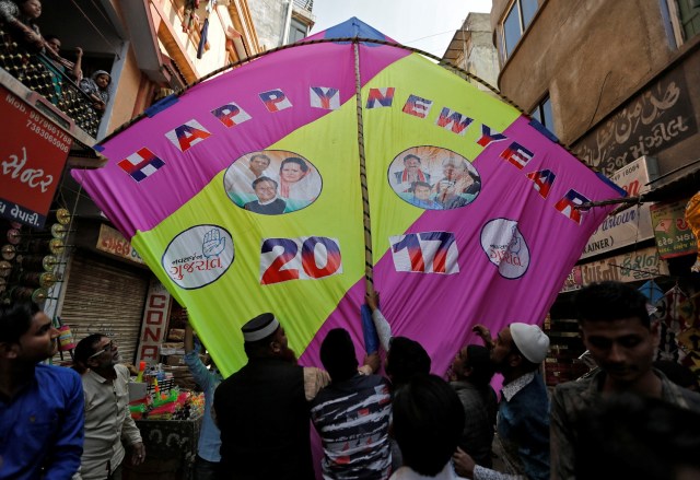 People fix a giant kite decorated with images of politicians to welcome the new year at a kite market in Ahmedabad, India, December 31, 2016. REUTERS/Amit Dave