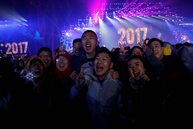 People pose for pictures as they attend a New Year's Eve countdown event in Beijing, China, December 31, 2016. REUTERS/Thomas Peter