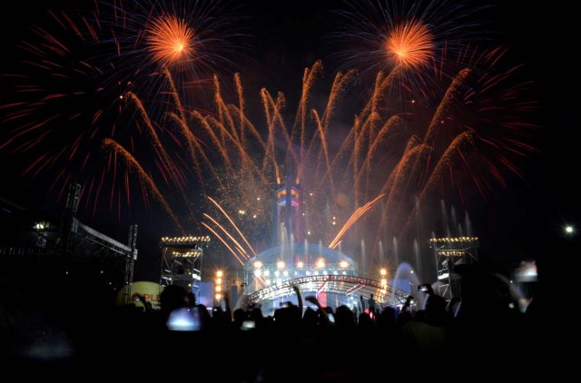 Revellers watch as fireworks explode over the Quezon Memorial Circle during New Year's celebrations in Quezon City, Metro Manila, Philippines January 1, 2017. REUTERS/Ezra Acayan