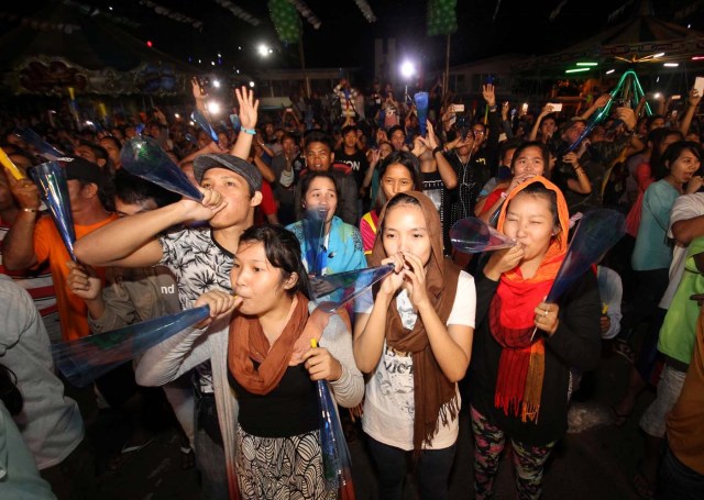 Revelers blow plastic horns to welcome the new year at the Rizal Park in Davao City, Philippines December 31, 2016. REUTERS/Lean Daval Jr