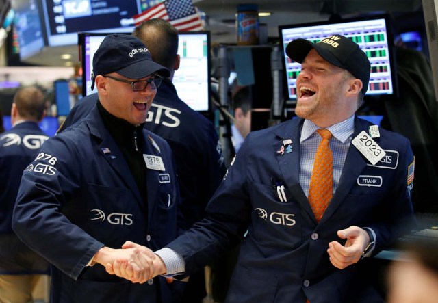 Traders celebrate on the main trading floor of the New York Stock Exchange (NYSE) as the Dow Jones Industrial Average passes the 20,000 mark shortly after the opening of the trading session in New York, U.S., January 25, 2017. REUTERS/Brendan McDermid     TPX IMAGES OF THE DAY