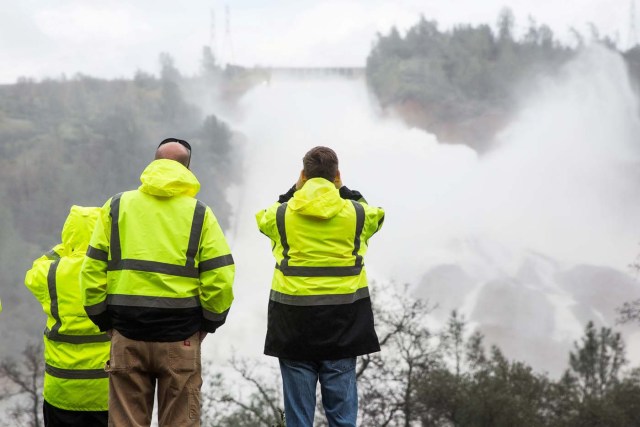 California Department of Water Resources personnel monitor water flowing through a damaged spillway on the Oroville Dam in Oroville, California, U.S., on February 10, 2017.