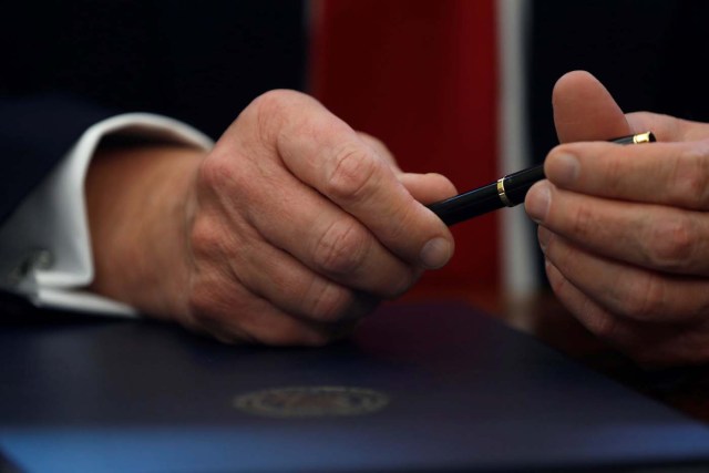 U.S. President Donald Trump prepares to sign an executive order on regulatory reform at his desk in the Oval Office at the White House, U.S. February 24, 2017. REUTERS/Jonathan Ernst