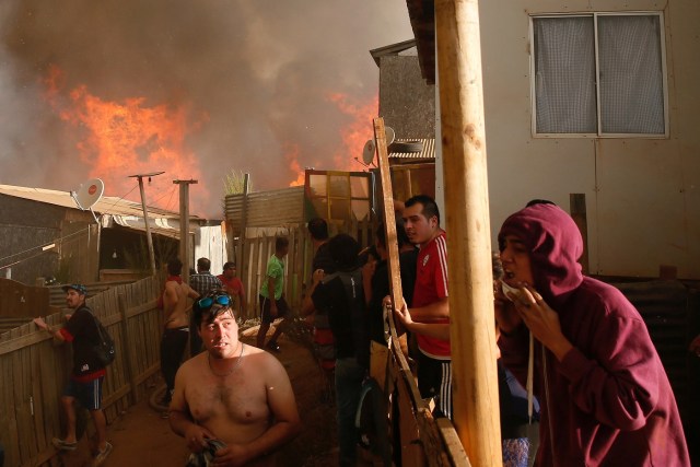 Residents work to prevent a wildfire from spreading to their homes in Vina del Mar, Chile, March 12, 2017. REUTERS/Rodrigo Garrido