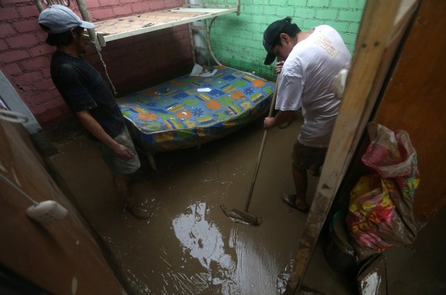 Flood survivors clean their house after rivers breached their banks due to torrential rains, causing flooding and widespread destruction in Huachipa, Lima, Peru, March 18, 2017. . REUTERS/Guadalupe Pardo