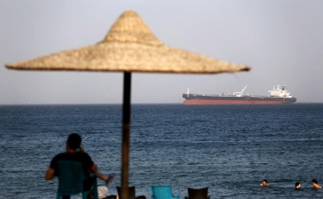 Imagen de archivo de gente bañándose en la playa del puerto de El Ain El Sokhna frente al petrolero egipcio "Sharifa 4" antes de entrar en el Canal de Suez, al este de El Cairo, Egipto. 26 julio 2015. El ministro del Petróleo de Egipto, Tarek El Molla, dijo el domingo que su país recibió dos cargamentos de combustible diésel de la compañía estatal saudita Aramco el viernes y el sábado. REUTERS/Amr Abdallah Dalsh - RTX1LVL2