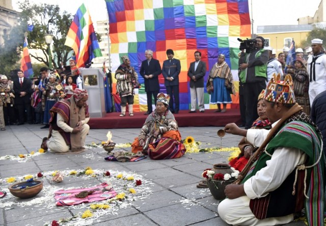 Bolivian President Evo Morales (C on stage), Vice-President Alvaro Garcia Linera (L) and the Minister of the Presidency Rene Martinez attend Andean rituals performed at a square in La Paz on March 21, 2017 as Morales's government submitted its response to a counter-suit filed by Chile at the International Court of Justice (ICJ), the latest legal wrangling in landlocked Bolivia's long-standing struggle to regain access to the Pacific Ocean. The two countries, currently locked in a bitter border dispute at the ICJ, severed diplomatic ties in 1978 and have a beef dating back to the War of the Pacific in the 19th century, when Bolivia lost its access to the sea to Chile. / AFP PHOTO / Aizar RALDES