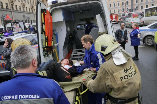 An injured person is helped by emergency services outside Sennaya Ploshchad metro station, following explosions in two train carriages at metro stations in St. Petersburg, Russia April 3, 2017. REUTERS/Anton Vaganov