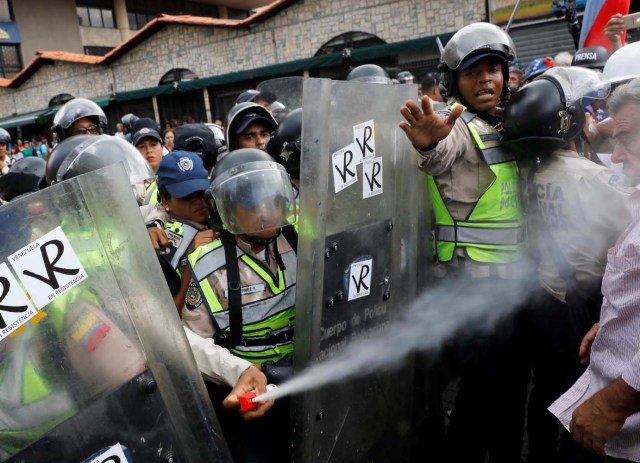Riot security forces uses a pepper spray as elderly opposition supporters confront them while rallying against President Nicolas Maduro in Caracas, Venezuela, May 12, 2017. REUTERS/Carlos Garcia Rawlins
