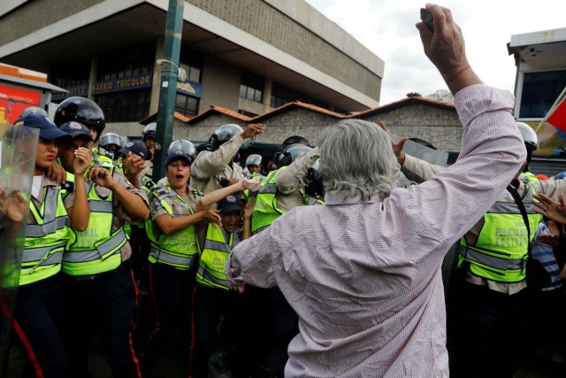 An elderly opposition supporter confronts riot security forces while rallying against President Nicolas Maduro in Caracas, Venezuela, May 12, 2017. REUTERS/Carlos Garcia Rawlins