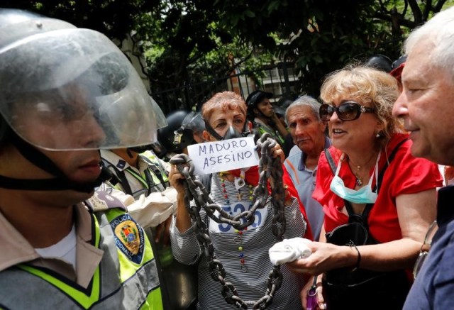 Un manifestante opositor protesta en contra del presidente Nicolás Maduro en Caracas con una pancarta, en Caracas, Venezuela, 12 de mayo de 2017. REUTERS/Carlos Garcia Rawlins - RTS16DQT