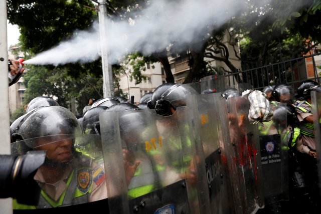A police officer uses pepper spray as opposition supporters confront riot security forces while rallying against President Nicolas Maduro in Caracas, Venezuela, May 12, 2017. REUTERS/Carlos Garcia Rawlins