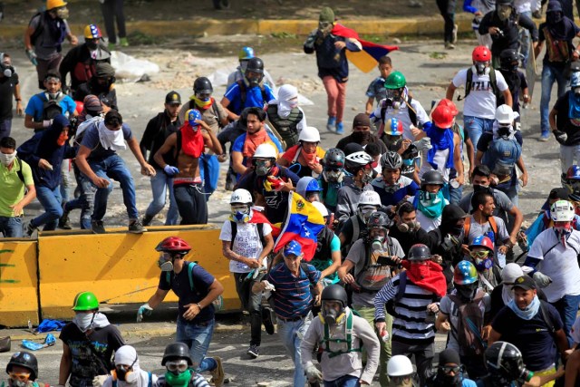 Demonstrators run while clashing with riot security forces during a rally against Venezuela's President Nicolas Maduro in Caracas, Venezuela, May 31, 2017. REUTERS/Christian Veron