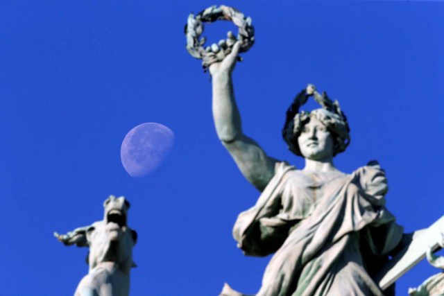 The moon is seen near the group statues on the facade Grand Palais during the traditional Bastille Day military parade on the Champs-Elysees in Paris, France, July 14, 2017. REUTERS/Stephane Mahe