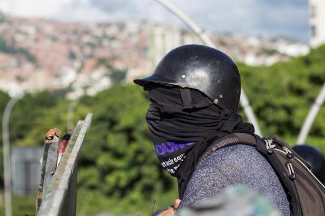 CAR301. CARACAS (VENEZUELA), 30/07/2017.- Manifestantes opositores bloquean una calle en rechazo a las elecciones de la Asamblea Nacional Constituyente hoy, domingo 30 de julio de 2017, en Caracas (Venezuela). Venezuela amaneció hoy en tensa calma y con focos de violencia y de enfrentamientos entre manifestantes antichavistas y las fuerzas de seguridad desde muy temprano, en esta jornada en la que se celebran las elecciones de la Asamblea Nacional Constituyente impulsada por el Gobierno de Nicolás Maduro. EFE/Nathalie Sayago