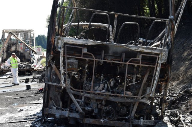 A forensic expert works on the site of a bus crash on the A9 highway near Muenchberg, southern Germany, on July 3, 2017. Up to 18 people were feared dead after a tour bus burst into flames following a collision with a trailer truck, police said. / AFP PHOTO / Christof Stache