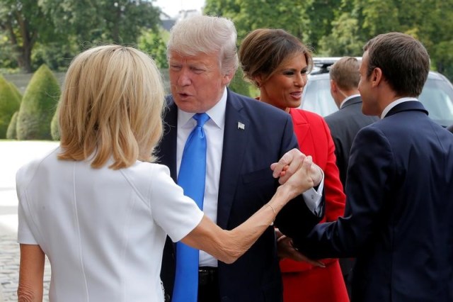 French President Emmanuel Macron (R) greets U.S First Lady Melania Trump while his wife Brigitte Macron (L) welcomes U.S. President Donald Trump at Les Invalides museum in Paris, France, July 13, 2017. REUTERS/Michel Euler/Pool - RTX3BAL9