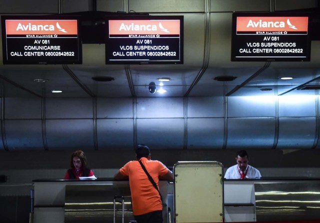 (FILES) This file photo taken on July 27, 2017 shows screens of Avianca Airline showing information of suspended flights at the airport of Maiquetia, Venezuela. A group of airlines have stopped flying to Venezuela since the the government owes them millions of dollars, and due to social unrest and insecurity, leaving the country increasingly isolated. / AFP PHOTO / RONALDO SCHEMIDT / TO GO WITH AFP STORY BY ALEXANDER MARTINEZ
