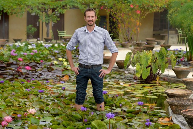 US-French Robert Sheldon poses among water lilies at the Latour-Marliac nursery in Le Temple-sur-Lot, southwestern France, on August 23, 2017. The Latour-Marliac nursery, a first of its kind in Europe, has been growing coloured water lilies since 1870 and was a source of inspiration for French painter Claude Monet's "Water Lilies" (Nympheas) series. / AFP PHOTO / Nicolas TUCAT