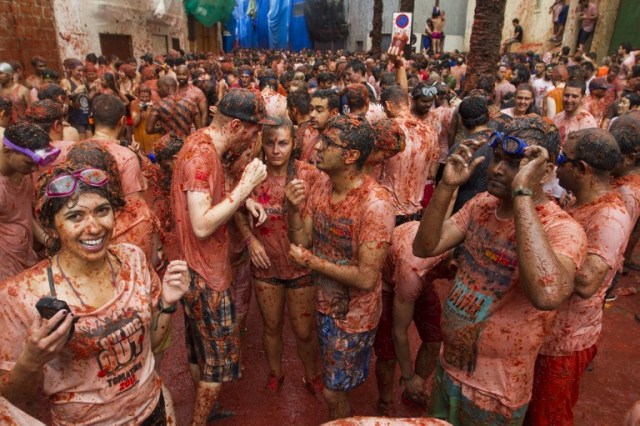 Revellers covered in tomato pulp take part in the annual "Tomatina" festival in the eastern town of Bunol, on August 30, 2017. The iconic fiesta -- which celebrates its 72nd anniversary and is billed at "the world's biggest food fight" -- has become a major draw for foreigners, in particular from Britain, Japan and the United States. / AFP PHOTO / JAIME REINA