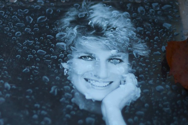 A photograph of Diana, Princess of Wales, covered by drops of water, is seen on August 30, 2017, left over the Alma bridge in Paris to mark the coming 20th anniversary of the death of Diana who died in a car crash in a nearby tunnel on August 31, 1997. The life of Diana -- a shy, teenage aristocrat who suddenly became the world's most famous woman -- and her tragic death at 36 still captivates millions across the globe. Diana died in a car crash in Paris in the early hours of August 31, 1997, along with Dodi Fayed, her wealthy Egyptian film producer boyfriend of two months, and a drink-impaired, speeding driver Henri Paul, who was trying to evade paparazzi. / AFP PHOTO / Eric FEFERBERG
