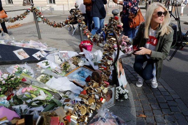 A woman stands next to flowers, messages, pictures and locks laid around the Flame of Liberty monument - which became an unofficial memorial for Diana, Princess of Wales who died in a car crash in a nearby tunnel - over the Alma bridge in Paris on August 31, 2017, on the 20th anniversary of the death of the Princess. The life of Diana -- a shy, teenage aristocrat who suddenly became the world's most famous woman -- and her tragic death at 36 still captivates millions across the globe. Diana died in a car crash in Paris in the early hours of August 31, 1997, along with Dodi Fayed, her wealthy Egyptian film producer boyfriend of two months, and a drink-impaired, speeding driver Henri Paul, who was trying to evade paparazzi. / AFP PHOTO / Patrick KOVARIK