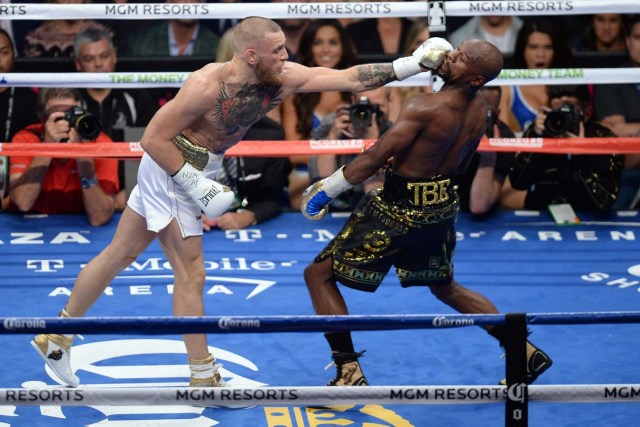 Aug 26, 2017; Las Vegas, NV, USA; Floyd Mayweather Jr. (black trunks) and Conor McGregor (white trunks) box during the fifth round of their boxing match at T-Mobile Arena. Mayweather won via tenth round TKO. Mandatory Credit: Joe Camporeale-USA TODAY Sports