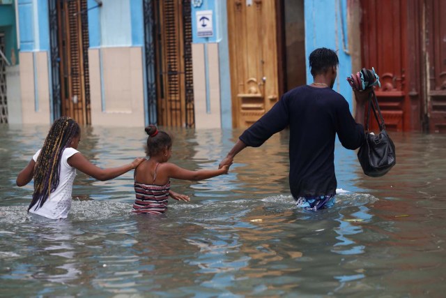 A man and two children wade through a flooded street, after the passing of Hurricane Irma, in Havana, Cuba September 10, 2017. REUTERS/Stringer NO SALES. NO ARCHIVES