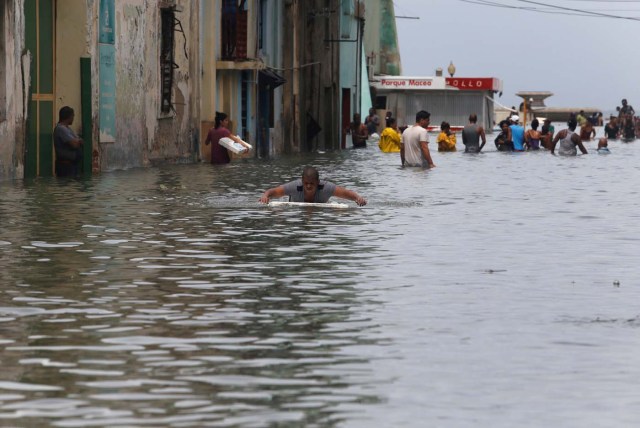 A man uses a piece of foam board to get through a flooded street, after the passing of Hurricane Irma, in Havana, Cuba September 10, 2017. REUTERS/Stringer NO SALES. NO ARCHIVES