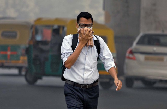 A man covers his face as he walks to work, in Delhi, India, November 7, 2017. REUTERS/Saumya Khandelwal