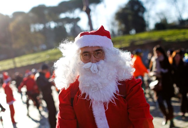 A man poses as more than a hundred cyclists dressed as Santa Claus meet at the Colosseum in Rome, Italy December 17, 2017. REUTERS/Tony Gentile