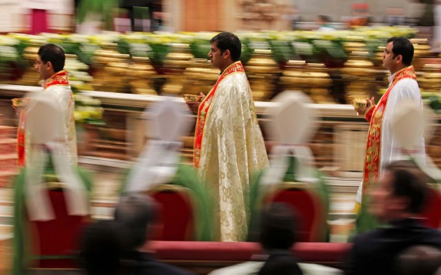 Priests walk as Pope Francis leads a special mass to mark International Migrants Day in Saint Peter's Basilica at the Vatican January 14, 2018. REUTERS/Max Rossi